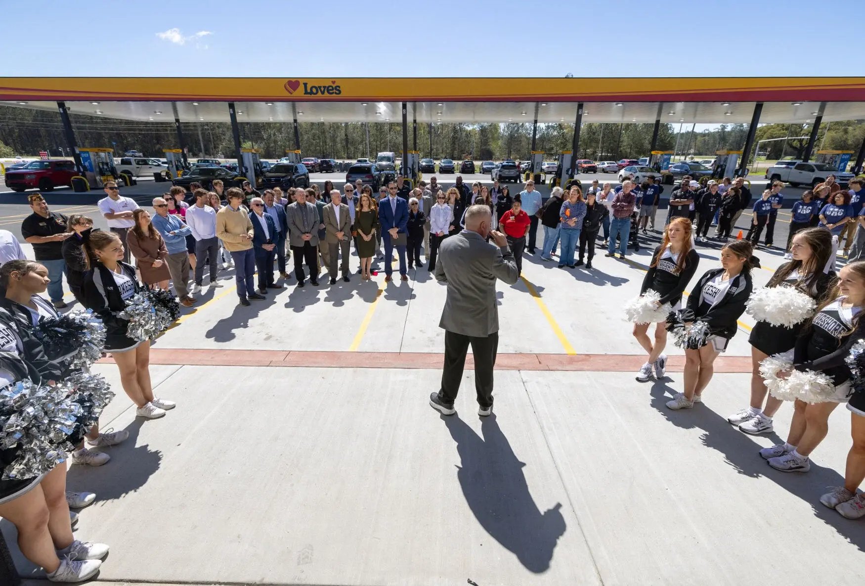 Love's Travel Stop Grand Opening with a cheerleading squad and community members celebrating in the parking lot